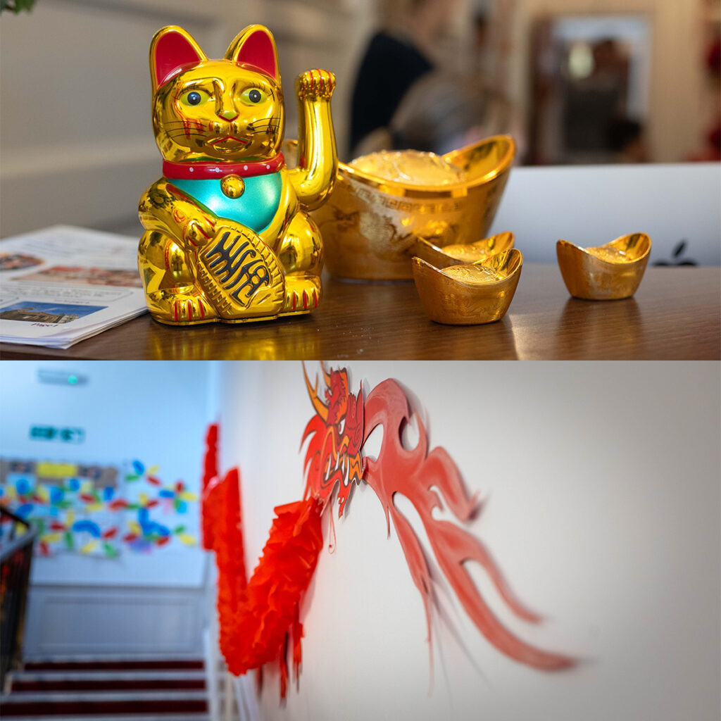 EIFA Top: A golden Maneki-neko (beckoning cat) with three gold ingots on a table. Bottom: A staircase adorned with a red dragon decoration on the wall, with colorful paper cutouts visible in the background.