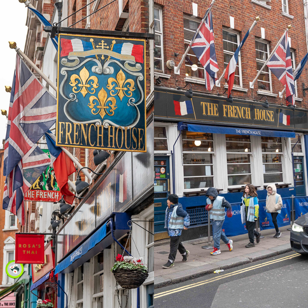 EIFA The image shows the exterior of The French House, a pub with a blue facade and multiple flags, including French and British, hanging outside. People walk past on the street. There’s also a sign for Rosas Thai nearby.